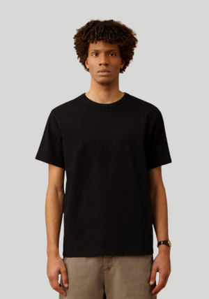 Person wearing a black t-shirt against a plain background